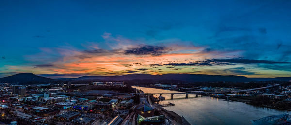 High angle view of buildings by sea against sky during sunset