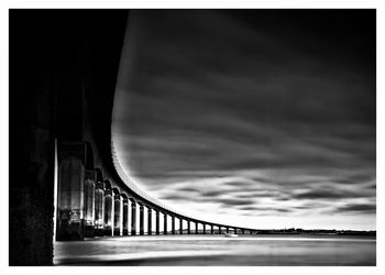 Low angle view of bridge against cloudy sky