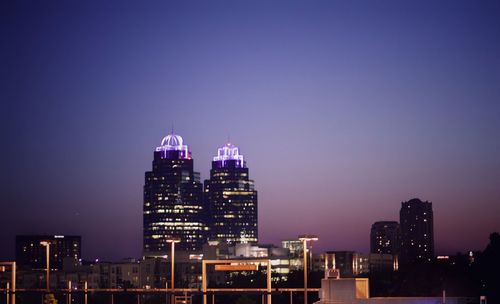 Illuminated buildings against sky at night