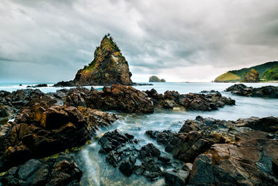 Scenic view of rocks in sea against sky