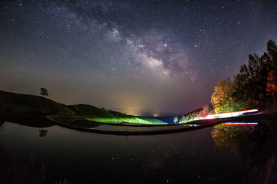 Scenic view of lake against sky at night