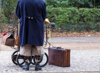 Low section of man with bicycle on bench