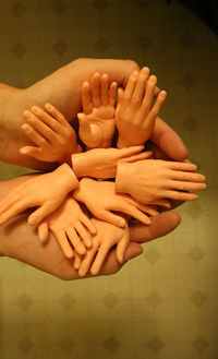 Cropped image of person holding artificial hands over tiled floor