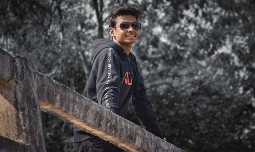 Portrait of young man leaning on railing