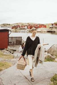 Portrait of smiling woman standing against built structure