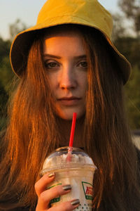 Portrait of a beautiful young woman drinking glass