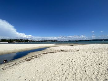 Scenic view of beach against blue sky