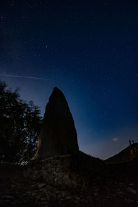 Low angle view of rock formation against sky at night