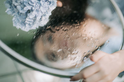 Close-up of woman holding glass of water