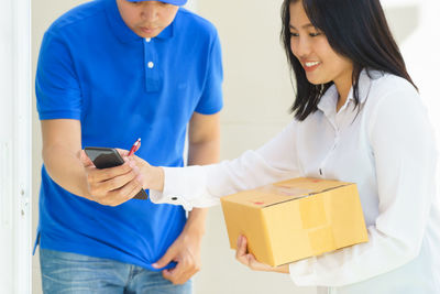 Midsection of woman holding mobile phone