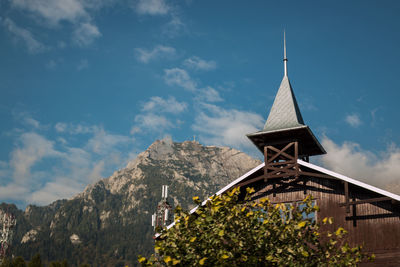 Low angle view of temple by building against sky