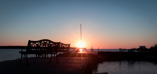 Pier on sea at sunset