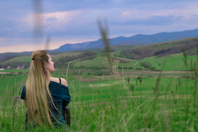 Woman standing on field against sky