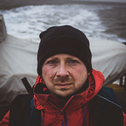 Close-up portrait of man wearing knit hat on boat in sea