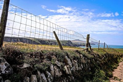 Low angle view of barbed wire fence against sky