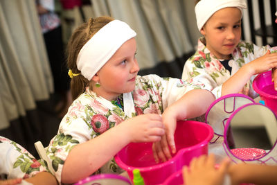 High angle view of girls cleaning hands with cotton pad in spa