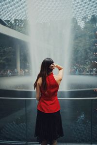 Rear view of woman standing by fountain outdoors