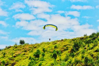 Low angle view of paragliding against sky