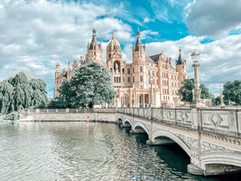 Arch bridge over river against buildings