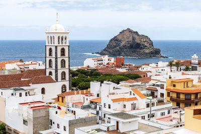 High angle view of townscape by sea against sky