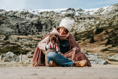 Full length of couple sitting on mountain