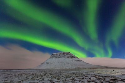 Scenic view of snowcapped mountain against sky at night