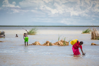 People on beach against sky