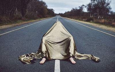 Low section of man with umbrella on road