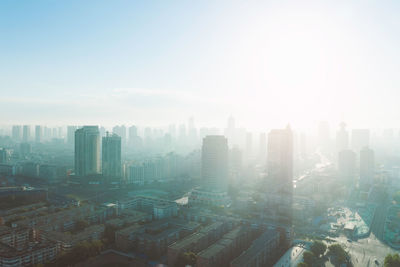 Aerial view of buildings in city against clear sky