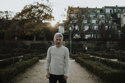 Mature man with gray hair standing in garden