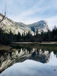Scenic view of lake by snowcapped mountains against sky