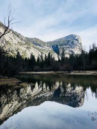 Scenic view of lake by snowcapped mountains against sky