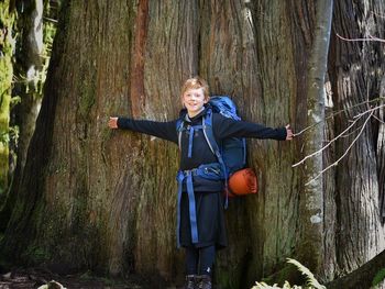 Boy with arms outstretched in forest