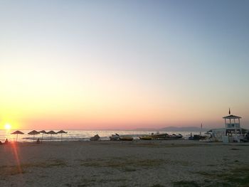 Scenic view of beach against clear sky during sunset