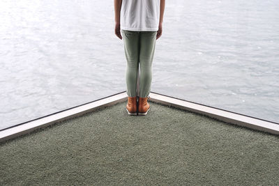 Low section of woman standing on tiled floor