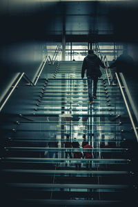 Rear view of people walking on staircase