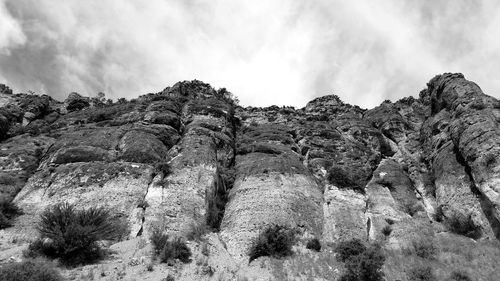 Low angle view of rocks on mountain against sky