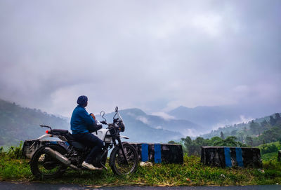 Young man motorcycle rider enjoy the beautiful mountain view at morning from flat angle