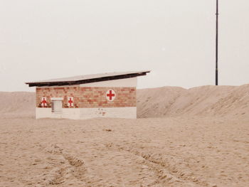 Hut on beach against clear sky