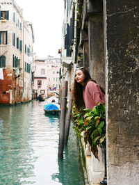 Young woman standing on sidewalk in city