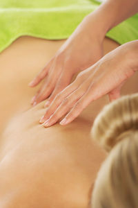 Cropped hands therapist massaging woman in spa