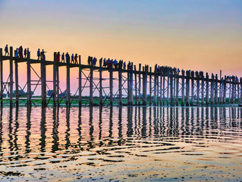 Pier on sea against sky during sunset