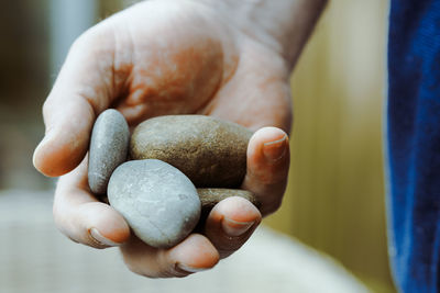Cropped hand of man holding stones