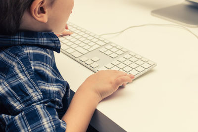 Close-up of boy using computer.