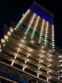 Low angle view of illuminated buildings against sky at night