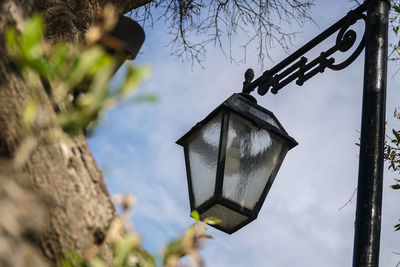 Low angle view of birdhouse hanging against sky