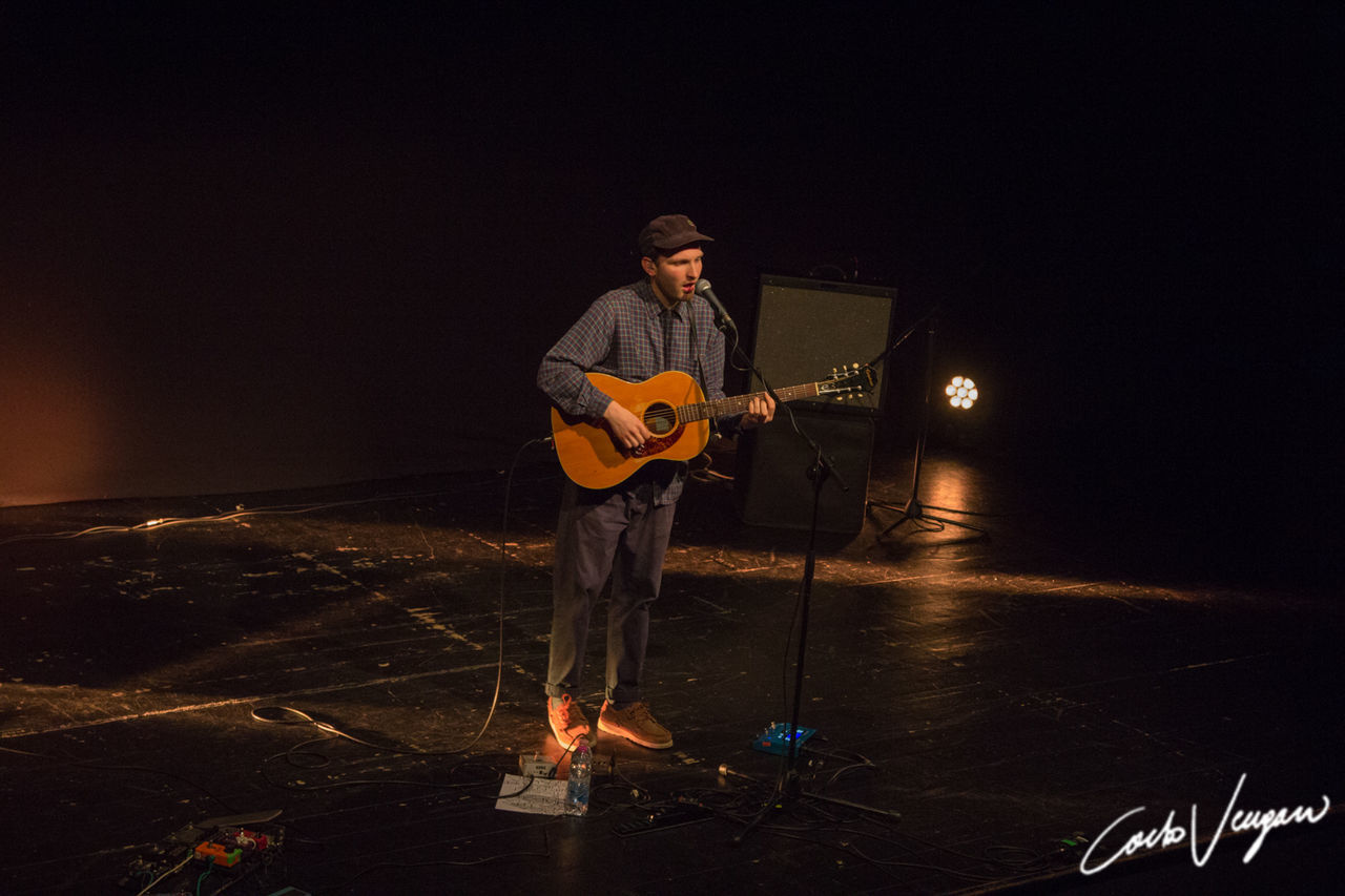 one person, music, musical equipment, night, real people, arts culture and entertainment, musical instrument, string instrument, illuminated, full length, musician, playing, guitar, standing, men, casual clothing, artist, nature, front view, skill, stage