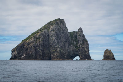 Rock formations by sea against sky