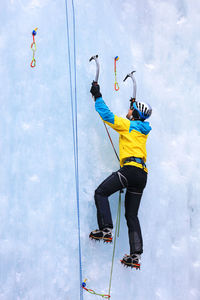 Side view of man ice climbing