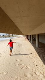 Rear view of man walking on beach